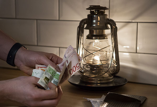 En hand som håller i sedlar