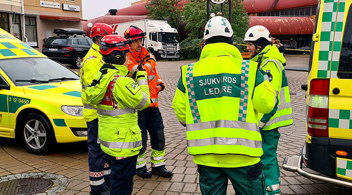 Ambulanspersonal pratar med varandra framför två ambulanser.