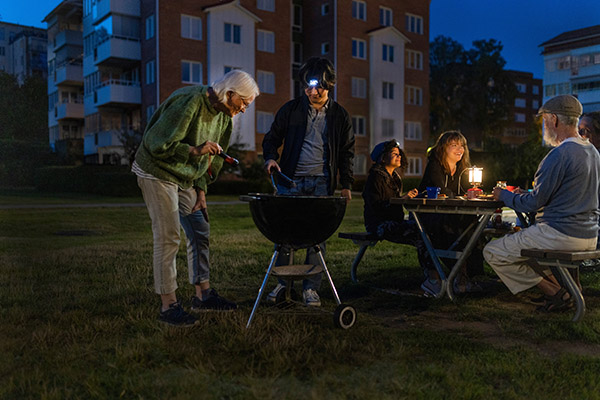 Grannar lagar mat på en grill utomhus