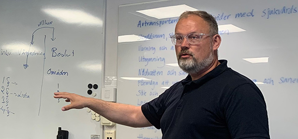 Henrik Larsson står framför en whiteboard.