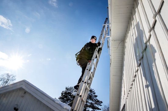 Skorstensfejare står på en stege