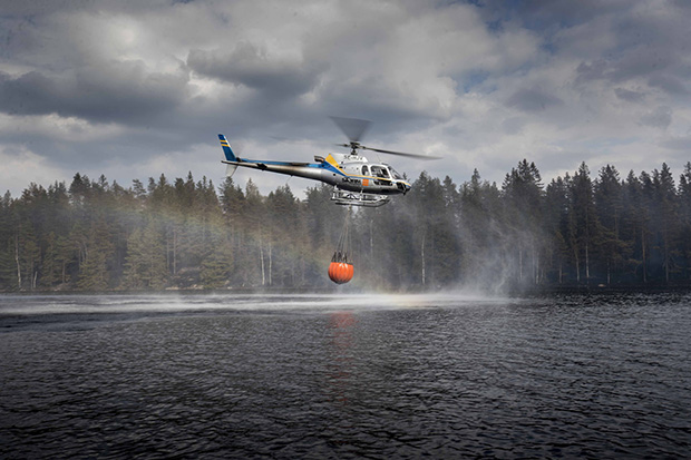 Helikopter flyger över sjö.