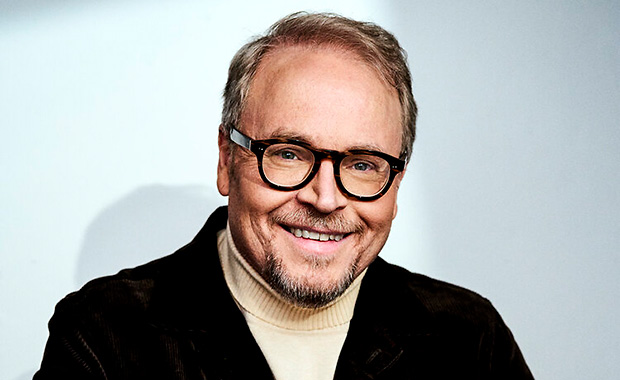 Porträtt av programledaren och komikern Fredrik Lindström i halvfigur. Leende man med glasögon.